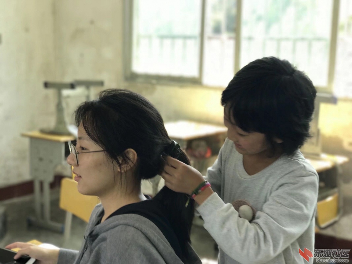 老师帮学生扎头发，师生间的温情互动